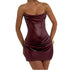 Woman wearing a strapless burgundy dress against a plain background
