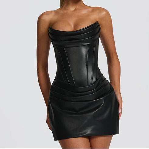 Woman wearing a black strapless dress against a gray background
