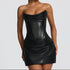 Woman wearing a black strapless dress against a gray background