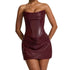 Woman wearing a strapless burgundy dress against a plain background