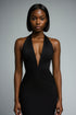 Woman wearing a black halter neck dress against a gray background