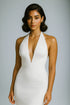 Woman wearing a white halter neck dress against a gray background