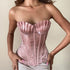 Pink corset worn by a model against a neutral background