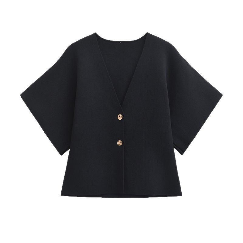 Black cape-style garment with gold buttons on a white background