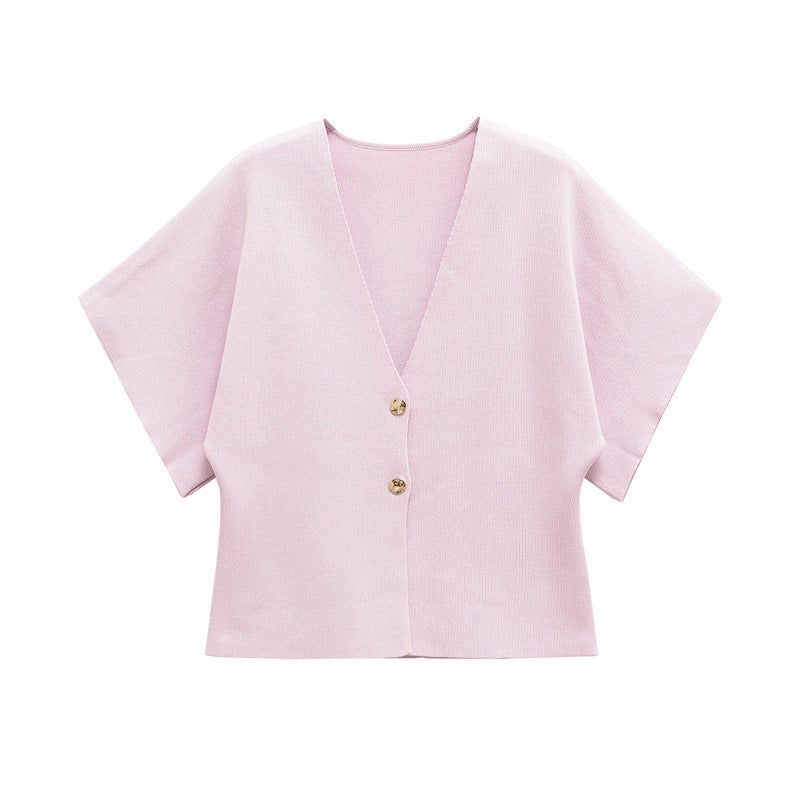 Light pink blouse with short sleeves and gold buttons on a white background